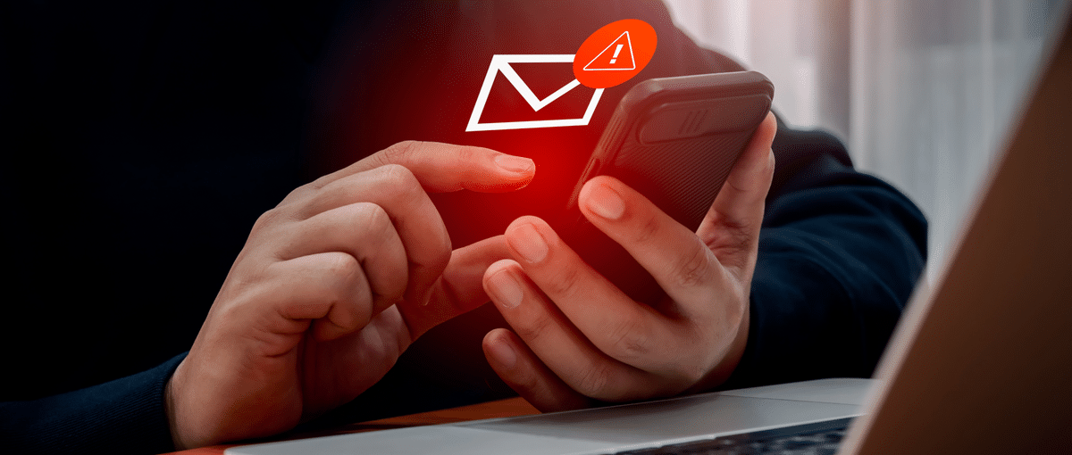 Mann bedient ein Handy und erhält eine verdächtige Mail