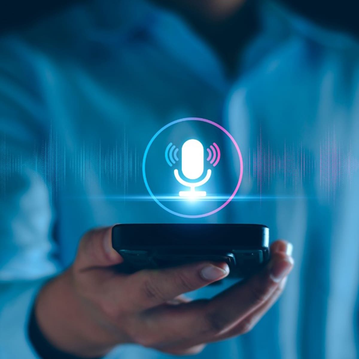 Person holding cell phone with microphone icon above it